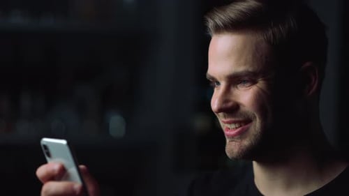 Close Up of Handsome Man Using Smartphone for Watching Video. Smiling Male