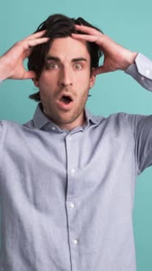 Stunned Man with Opened Mouth in Blue Studio