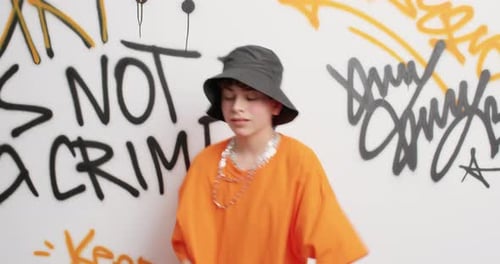 Teen Boy with Bucket Hat Dances in Graffiti Studio