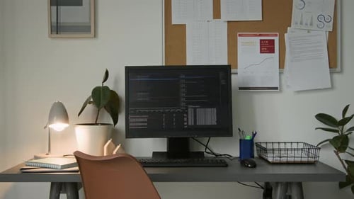 Schreibtisch eines Softwareingenieurs mit Computercode auf schwarzem Bildschirm im Startup Office