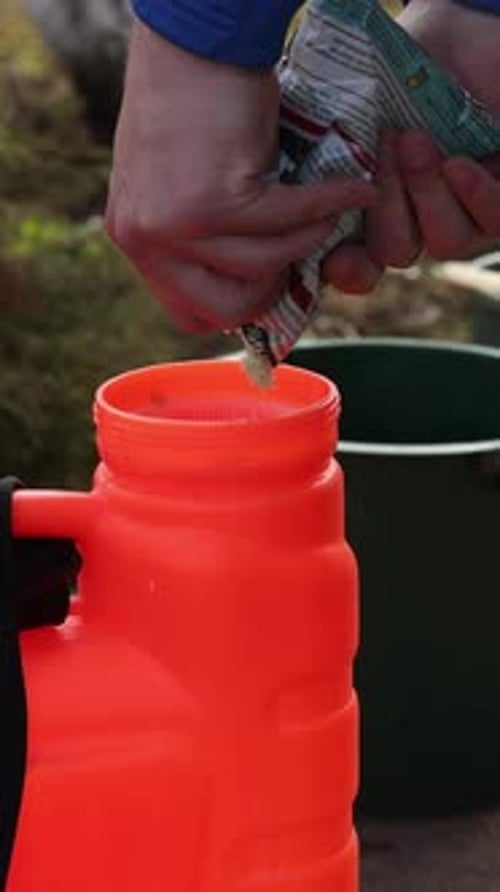 Vertical Gardener Preparing Insecticide Chemical Solution in Pressure Sprayer