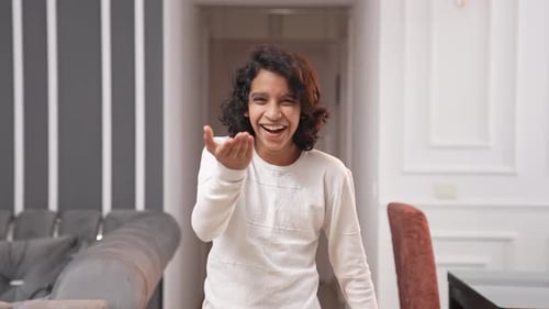 Smiling Person Waving in Bright Indoor Living Room