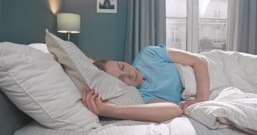 Woman Sleeping Soundly in Bed in Bedroom