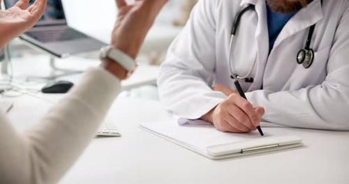 Doctor Taking Notes While Speaking with Patient