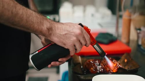 Chef Using Culinary Torch to Caramelize Food in Kitchen