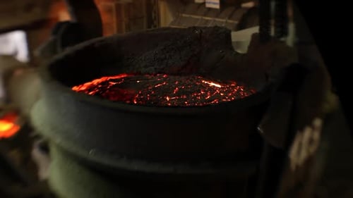 Molten metal glowing in industrial foundry, vivid heat and industrial atmosphere, selective focus