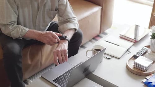 Senior Man Using Smartwatch at Home
