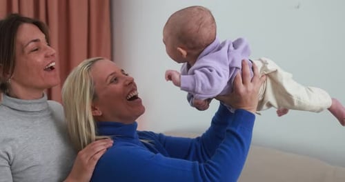 Joyful Women Playing with Adorable Baby Indoors