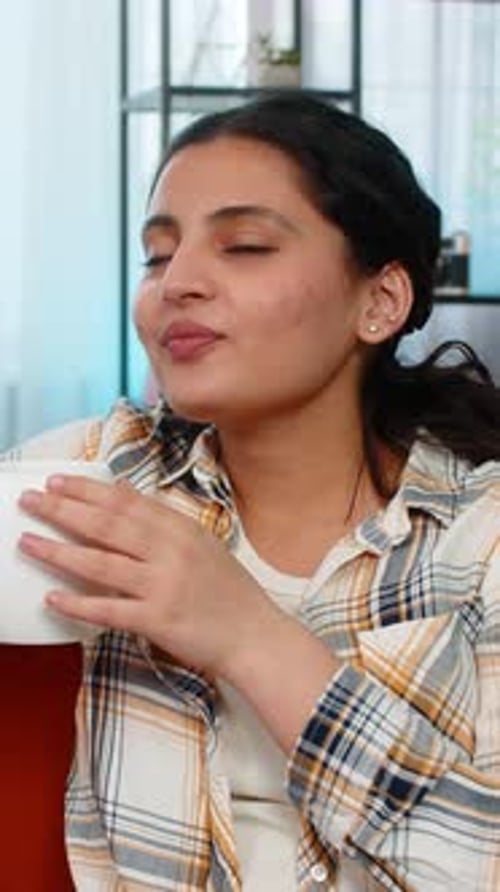 Young Woman Drinking Beverage Relaxing on Couch