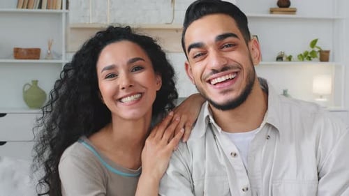 Cheerful Couple Waving and Talking Indoors