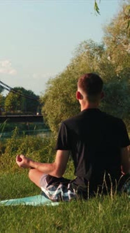 Young Man Meditating Outdoors in Peaceful Nature Setting