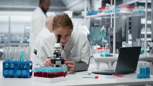Woman Scientist Using Microscope in Modern Laboratory