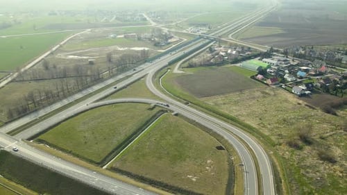 Blick von der Drohne: Straßenverkehr außerhalb der Stadt in der Nähe der grünen Wiese