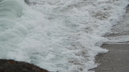 Epic slow motion of turbulent sea wave with foam shot with tele lens.