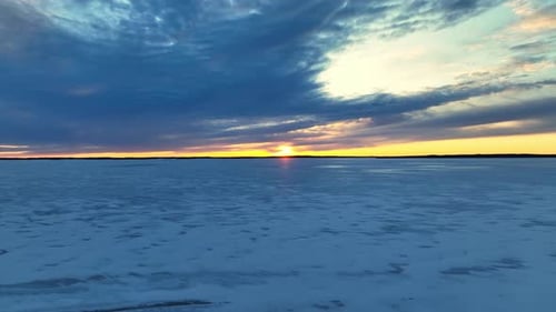 Footage over a frozen lake at sunset