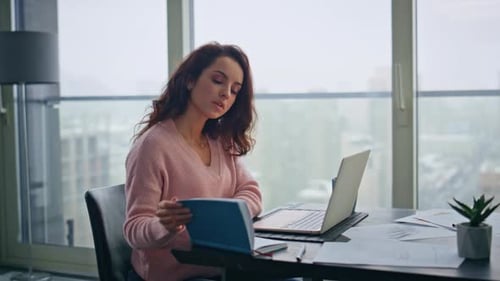 Nachdenklicher Manager arbeitet am Laptop in einem entfernten Büro, Nahaufnahme, Frau, Notizbuch