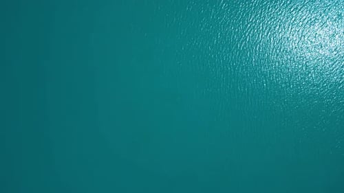 Water surface with sun reflection, aerial top down view