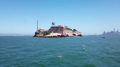Gimbal moving shot approaching the backside of Alcatraz Island by boat with the Bay Bridge and San F
