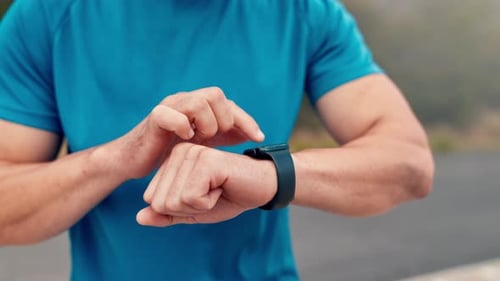 Athletic Man Using Smartwatch in Outdoor Setting