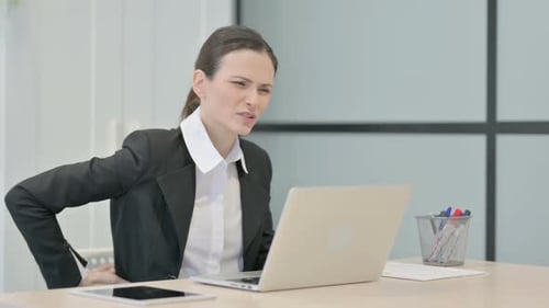 Businesswoman Experiencing Back Pain While Working on Laptop