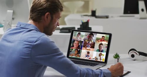 Caucasian male teacher using laptop on video call with school children