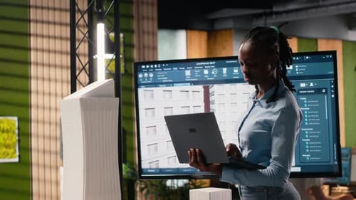 Black Female Developer Reviewing Zoning Regulations with 3D Models
