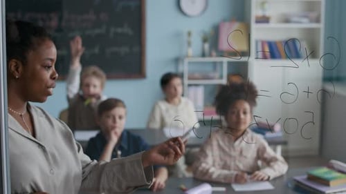 Teacher Explaining Math to Elementary School Students