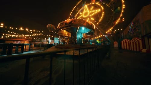 An Empty Amusement Park at Night with Colorful Lights and Deserted Rides