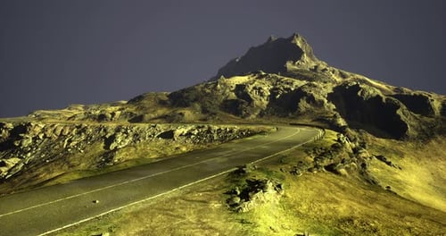 Scenic Winding Road Leading to a Mountain Summit Under Evening Sky