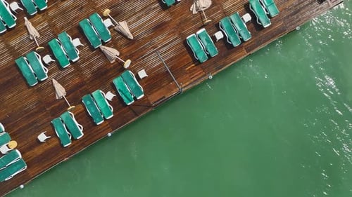 Vídeo aéreo de um píer de madeira que se estende sobre ondas turbulentas do mar com fortes ondas caindo abaixo