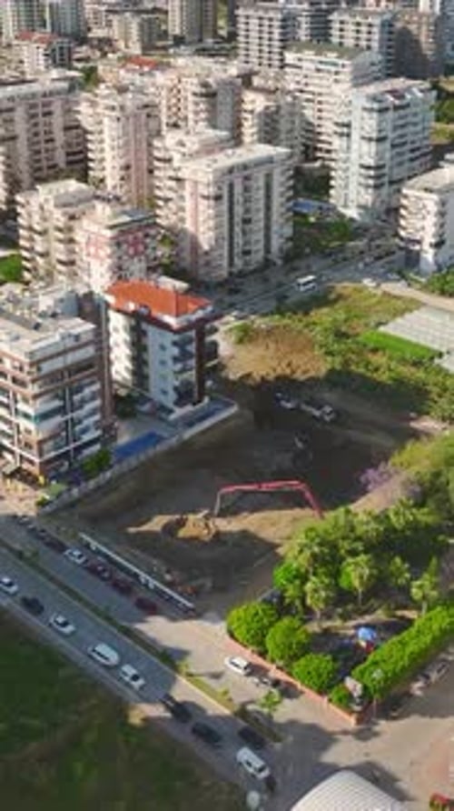 Constructores y máquinas de vídeo verticales en acción en una obra de construcción muy transitada