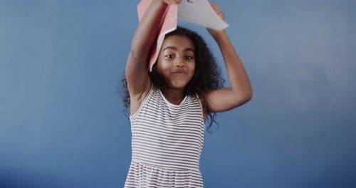 Girl Puts Book on Head and Smiles