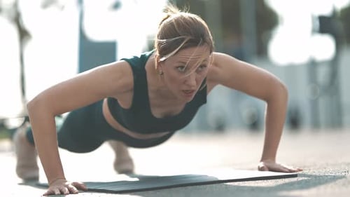 Woman Doing Pushups Outdoors in Sunlight