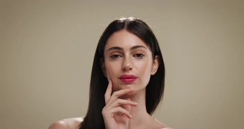 Beauty, makeup and hand with face of woman in studio for lipstick, cosmetics and foundation glow