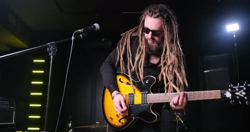 Guitarist Man Plays an Electric Guitar Closeup at Studio