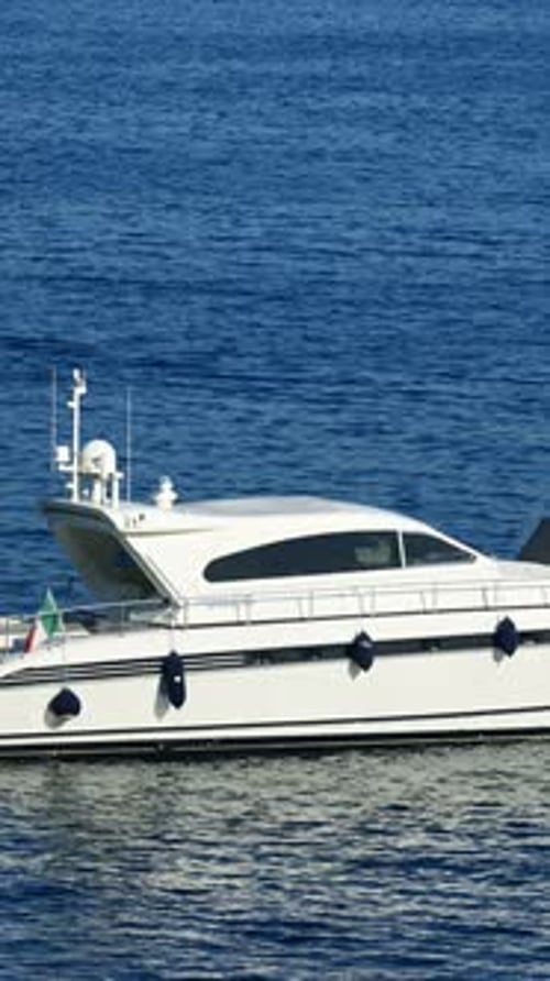 White boat docked in the local harbour in Villefranche sur Mer, France. Vertical