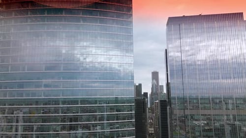 Faszinierender rosafarbener Himmel, der sich in den Spiegelfenstern der Wolkenkratzer spiegelt. Beeindruckende Architektur