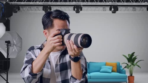 Close Up Of Asian Photographer Using A Camera Taking Picture In The Studio