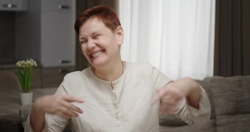 The Woman Heard a Funny Joke Very Loudly and Emotionally Laughs Waving Her Hands and Wipes Tears of