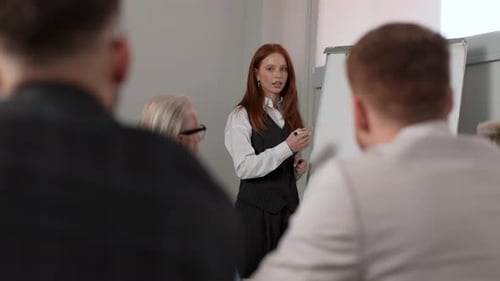 Closeup View From Back of Unrecognizable Colleagues to Young Female Executive Leader Coach Presenter