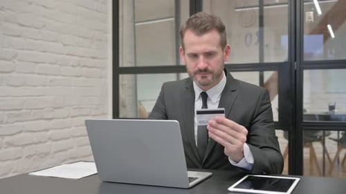 Man in Suit using Laptop with Credit Card