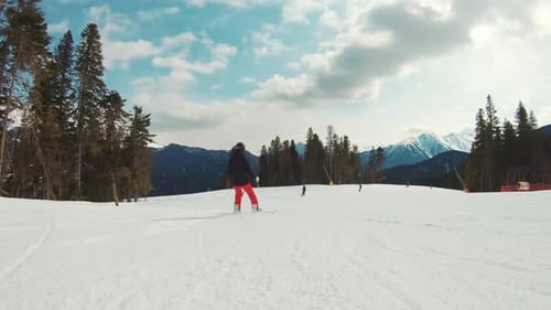 Rear View Athlete Snowboarder Ride Down Slope Hill on Snowboard and Performs Maneuverable Movements