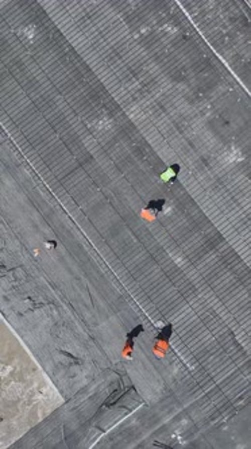 Vertical Video Construction Workers Prep the Foundation for Concrete Pouring By Bending Rebar at a