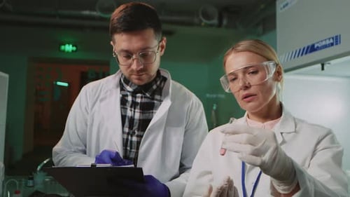 Scientists Analyzing Vial in Medical Laboratory Setting