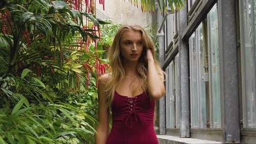 Slim bikini model walking in a beautiful botanic garden.