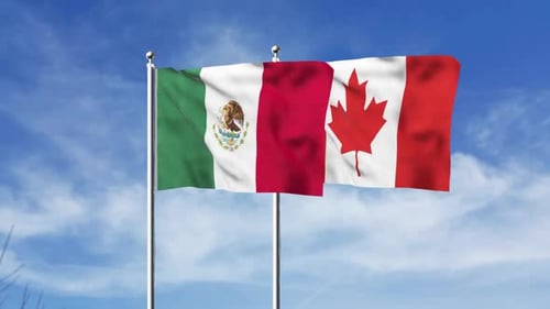 Waving Mexico and Canada Flags Against Blue Sky