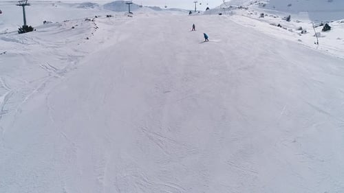 Aerial View of Snowboarders on a Sunny Slope