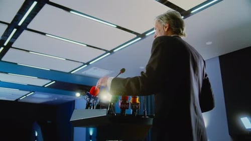 Mature Activist Pronounce Speech From the Tribune in the Conference Hall