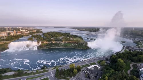 Scenic Aerial View of American and Canadian Niagara Falls with Urban Cityscape at Sunset, Canada