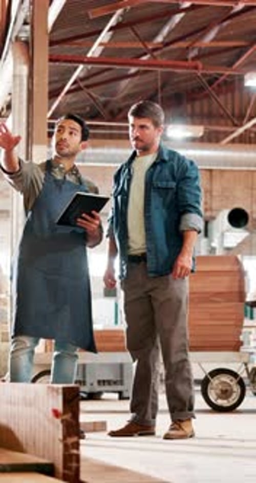 Men, carpenter and tablet at factory, planning and team talk at furniture manufacturing job
